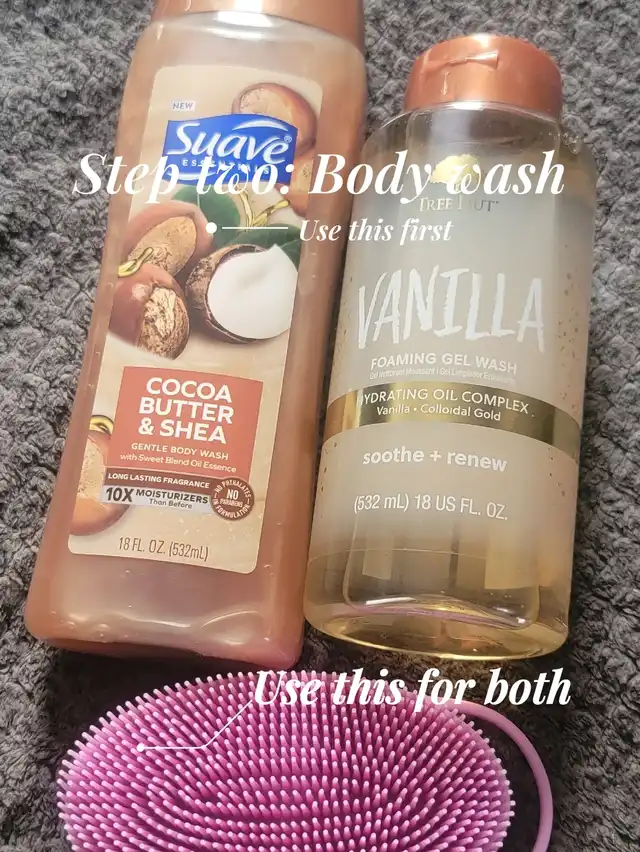 Two bottles of body wash, one brown and one clear with a vanilla label, are shown with a pink body brush on a gray textured surface. Overlay text states "Step two: Body wash" and provides usage instructions.