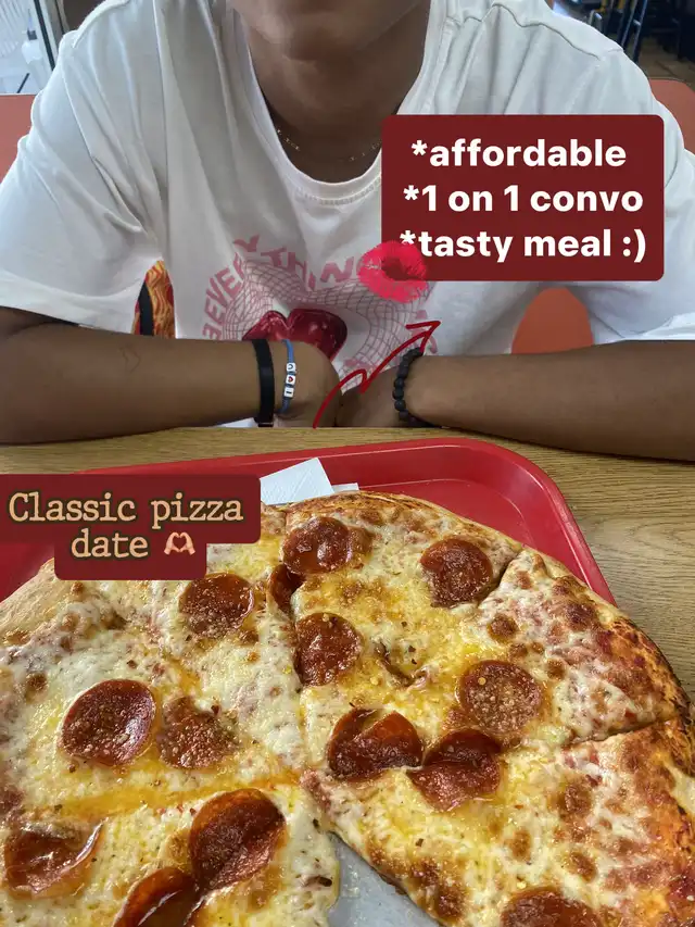 A top-down view of a large pepperoni and cheese pizza on a red tray, with a person's arms resting on the table. Text overlays describe it as a "Classic pizza date" that is affordable, good for 1-on-1 conversation, and a tasty meal.