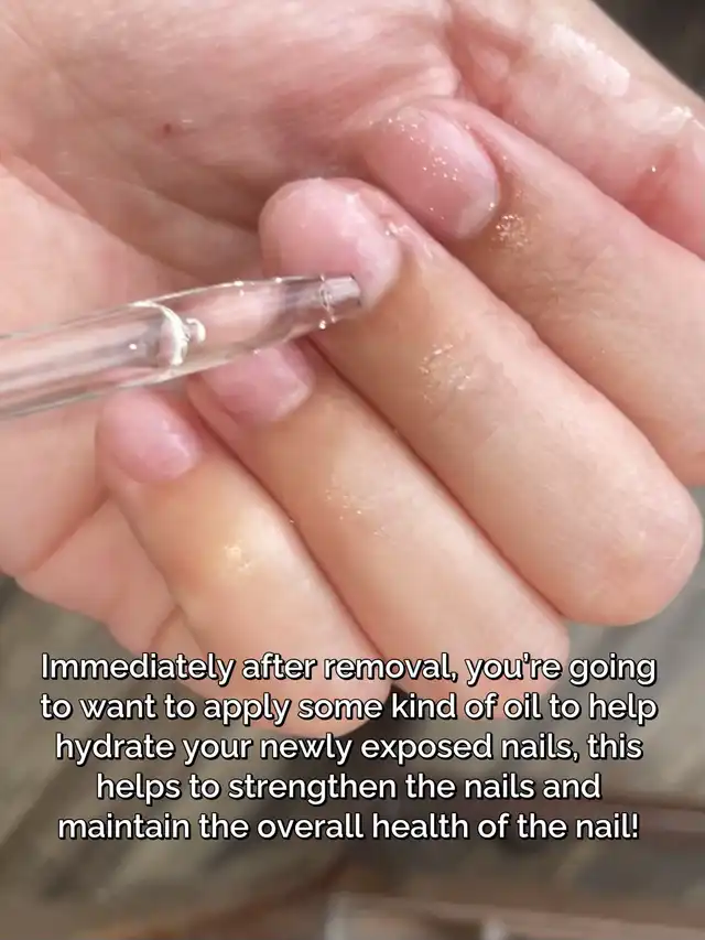 A hand receiving nail oil application from a dropper onto bare, exposed nail beds, emphasizing hydration and strengthening after acrylic removal.