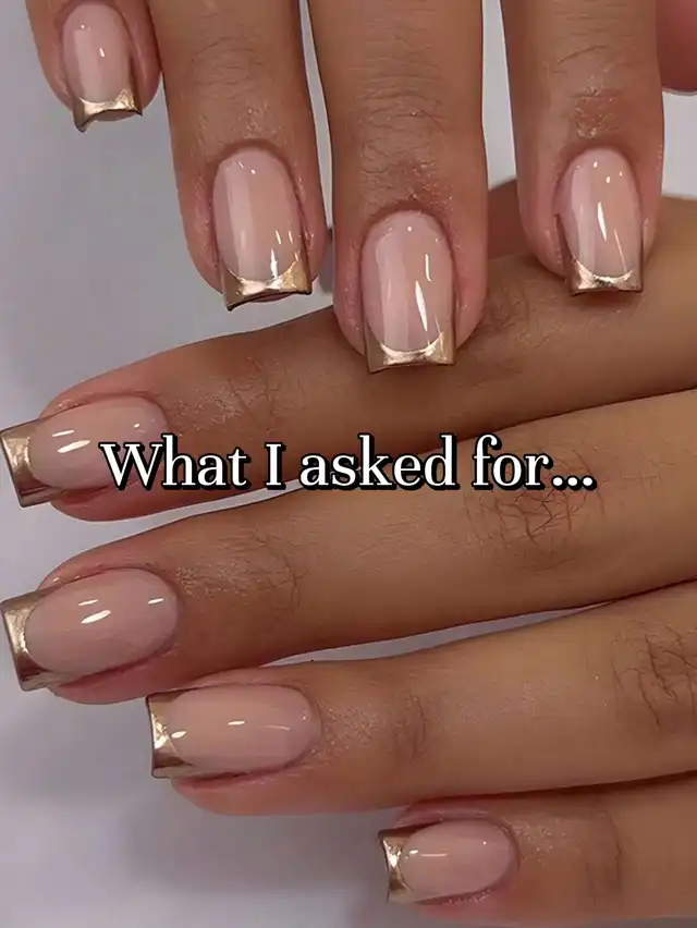 A close-up of a hand displaying square-shaped nails with a nude base and metallic gold French tips. The image is labeled "What I asked for...".