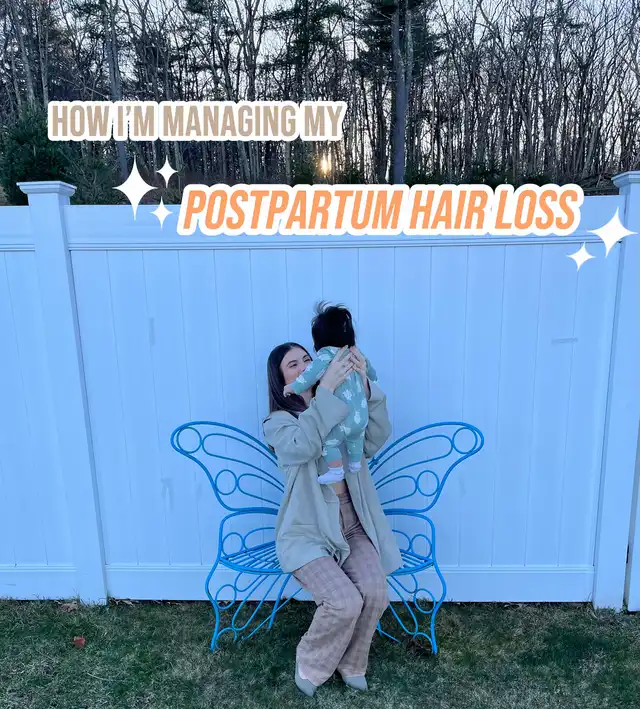 A woman holding a baby, sitting on a blue butterfly bench, with text "HOW I'M MANAGING MY POSTPARTUM HAIR LOSS" overlaid, illustrating the article's theme.